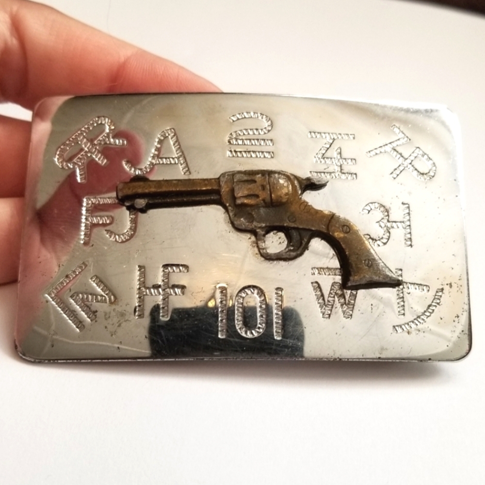 Vintage belt buckle with revolver and ranch brand symbols Chambers